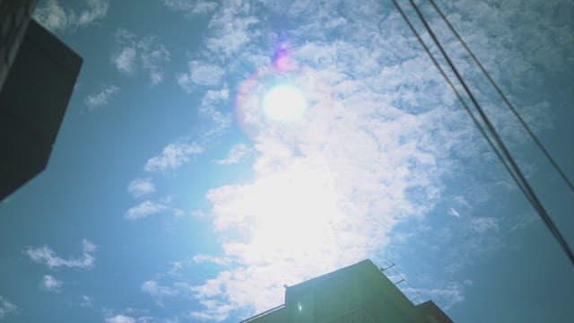 건물 위로 구름이 펼쳐진 화창한 하늘