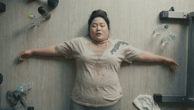 Tired obese woman lying on gym floor