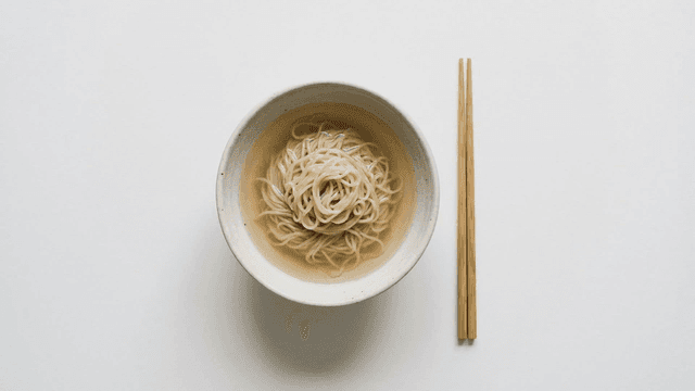 Bowl of warm noodles placed with chopsticks