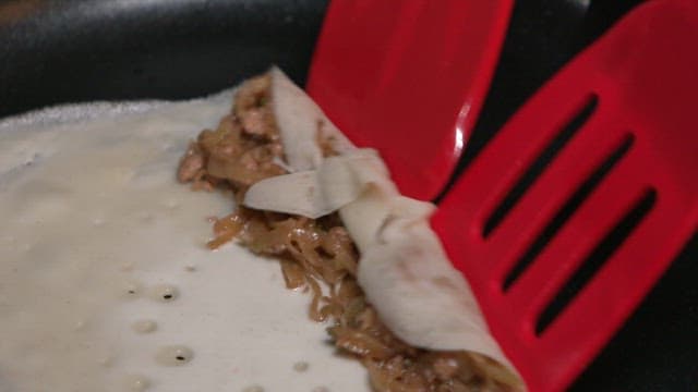 Rolling buckwheat pancakes from a frying pan using a flipper
