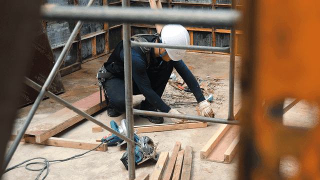 건설 현장에서 나무를 측정하는 작업자