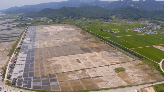 산을 배경으로 한 넓은 염전과 농경지