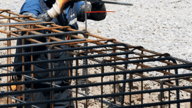 Construction worker handling steel bars