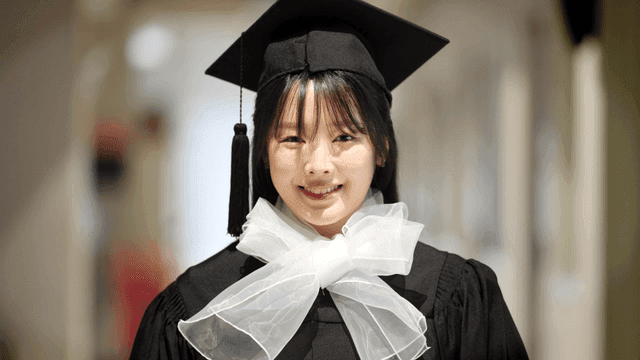 Female graduate smiling in hallway