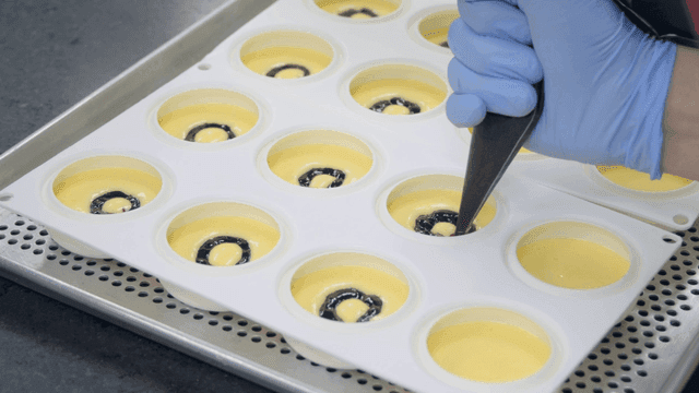 Filling dessert molds with cream and sauce