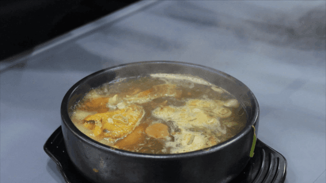 뚝배기에 담긴 끓고 있는 상황버섯 삼계탕