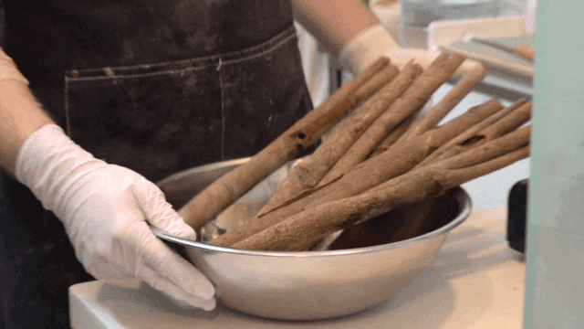 Holding a bowl filled with dried cinnamon sticks