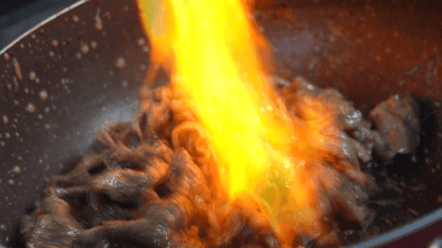 Cooking meat over direct flame in pan on stove