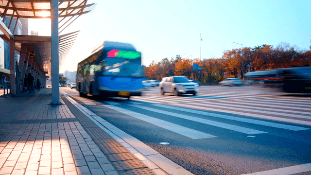 Buses and cars moving at autumn road intersection