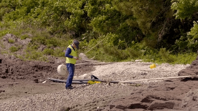 바위 해변에서 작업하는 사람