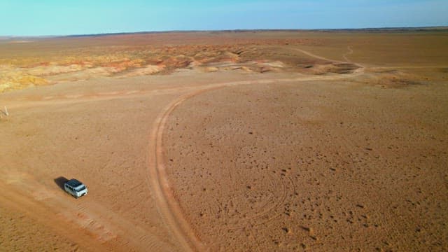 Off-road vehicle trekking through vast desert