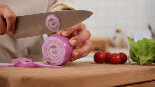 Chopping red onions on wooden cutting board