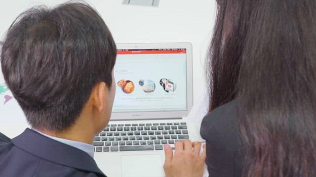 Two Professionals Preparing Presentation on a Laptop