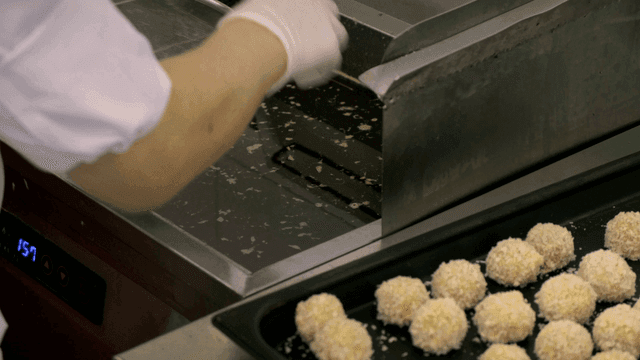 튀김기에 튀김을 넣는 요리사