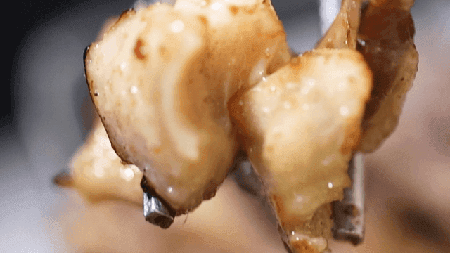 Grilled beef intestines held with chopsticks