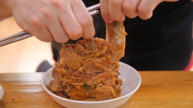 Hands preparing to eat pork backbone stew