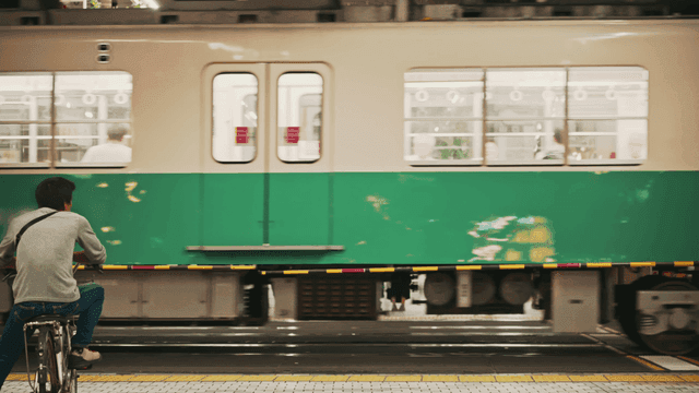 People waiting at a train crossing in the city