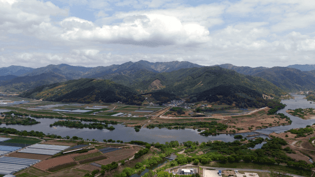 Expansive farmland with mountains and river