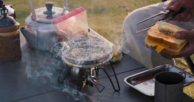 Preparing grilled cheese sandwich outdoors