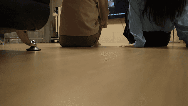 Back view of mother and daughter sitting on floor watching TV