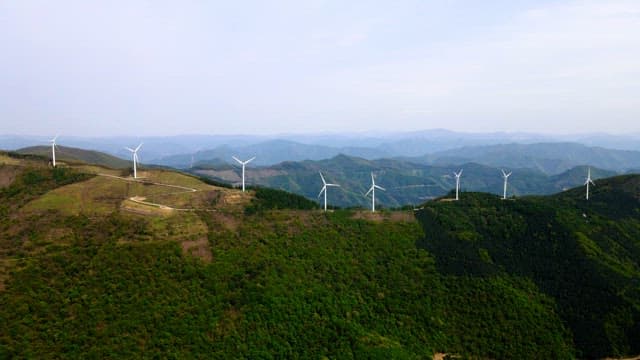 Wind turbines on a lush green mountain range