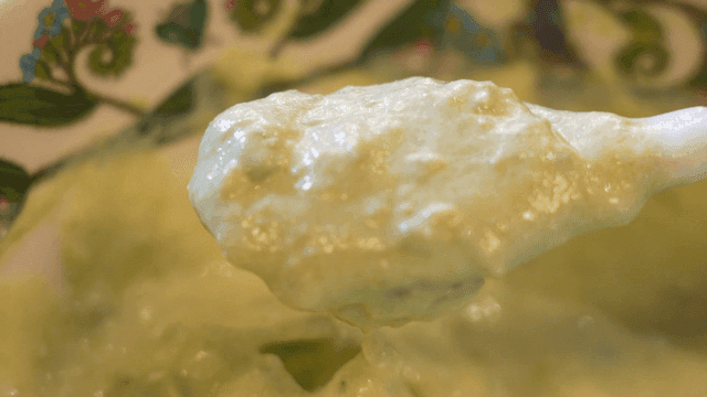 Green avocado guacamole stirred in bowl