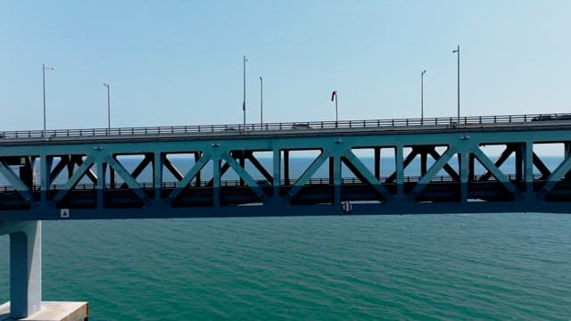 Vehicles crossing a Gwangan Bridge over the calm sea on a clear day