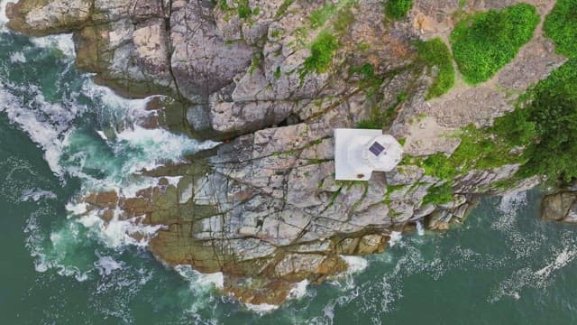 Lighthouse on rocky cliffs by the sea