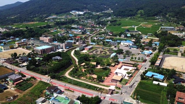 산을 배경으로 하고 있는 녹지가 많은 한적한 마을