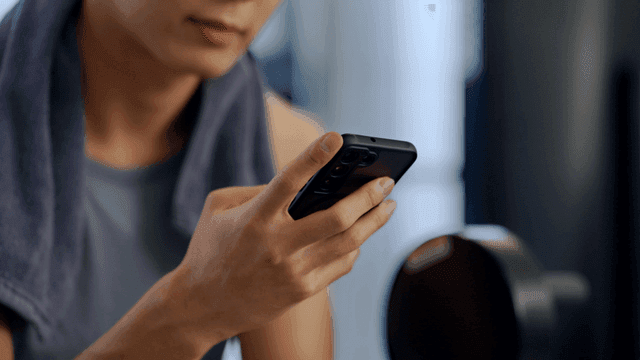 헬스장에서 스마트폰을 사용하는 남성