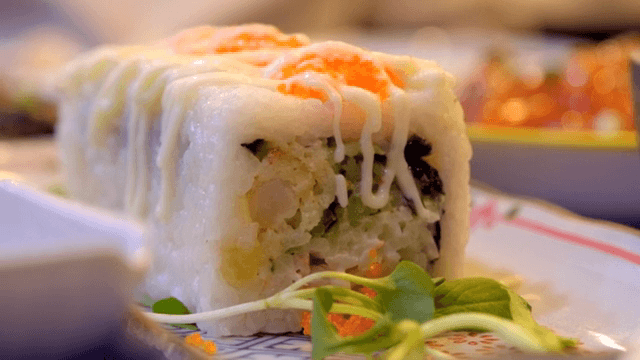 Sushi roll with creamy sauce and garnish