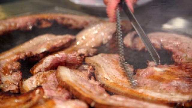 Close-up of Sizzling Pork Belly on a Grill