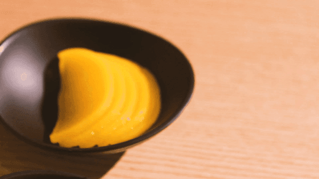 Sliced yellow pickled radish in a bowl