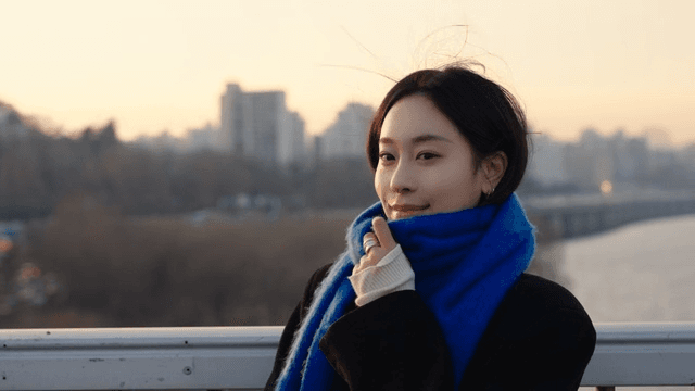 Woman smiling on a river bridge at sunset