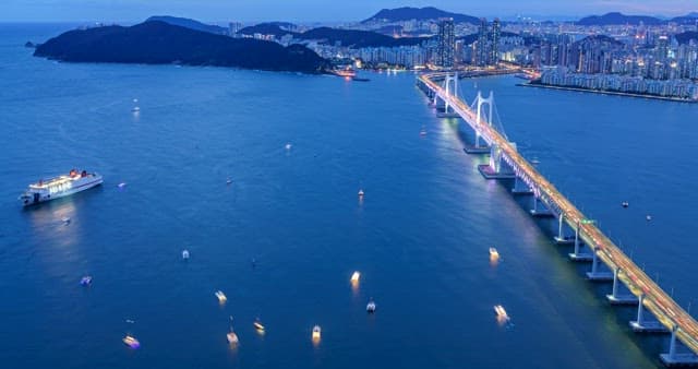 밤에 광안대교 근처 바다를 떠다니는 요트들