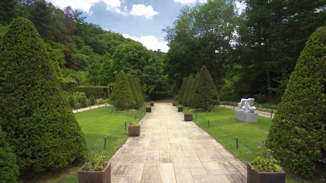 조각과 녹음이 어우러진 고요한 정원 길