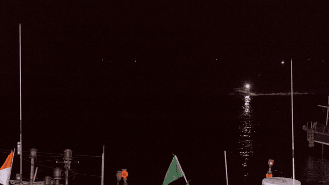 Fishing boats cutting through night sea