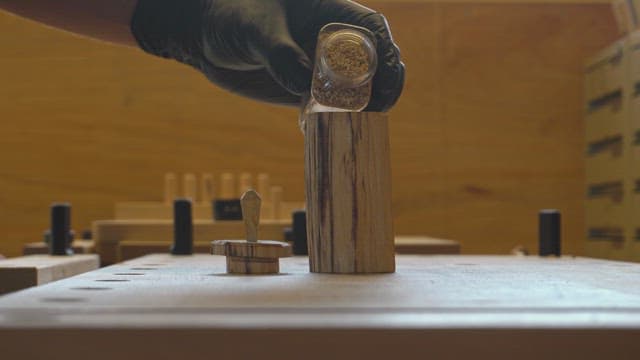 Hand putting powder into a wooden barrel