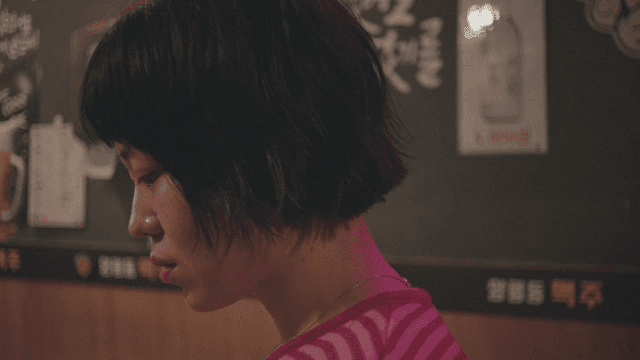 줄무늬 셔츠를 입고 불쾌하다가 웃는 여성