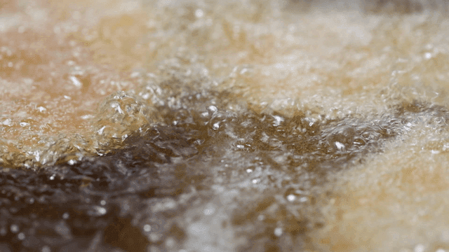 Fried food in boiling oil in frying pan