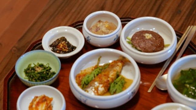 Traditional Wooden Table with Korean Side Dishes such as Stewed Fish and Tteokgalbi