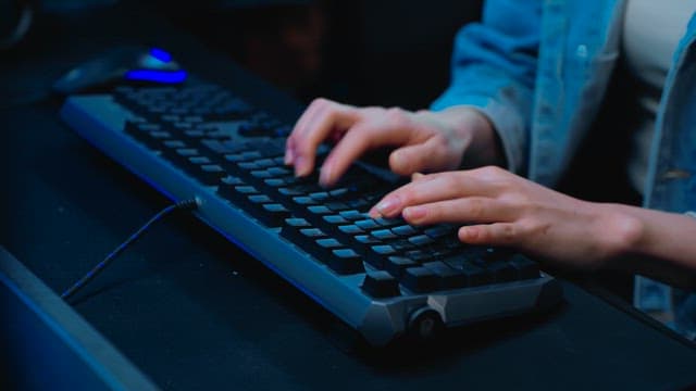 백라이트 키보드를 빠르게 타이핑하는 손