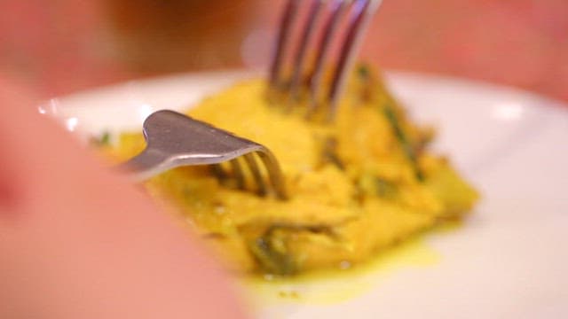 먹음직스러운 닭고기 요리를 포크로 집는 모습