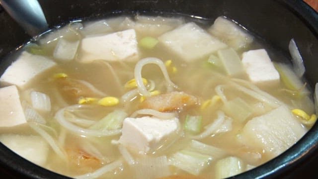 숟가락으로 황태해장국을 뜨는 장면