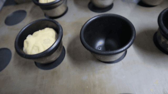 장갑 낀 손으로 틀에 준비하는 반죽