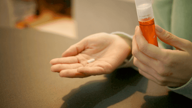 Pouring vitamin pills into hand