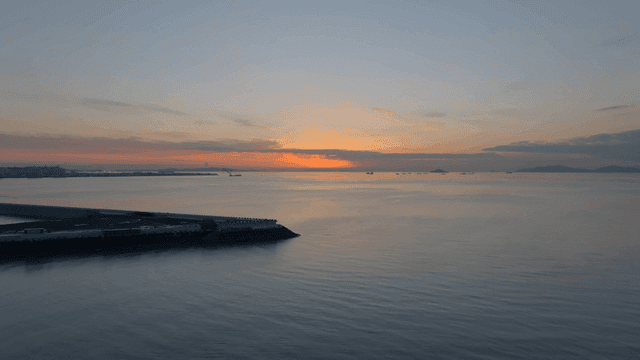 멀리 배가 있는 고요한 바다의 일몰