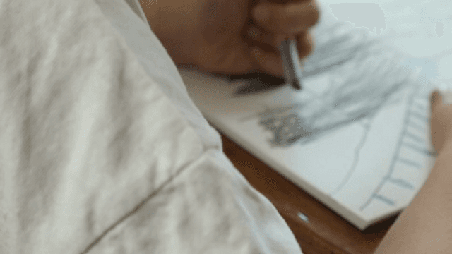 사람이 스케치북에 그림을 그리는 모습