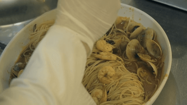 Seafood pasta being prepared in a kitchen