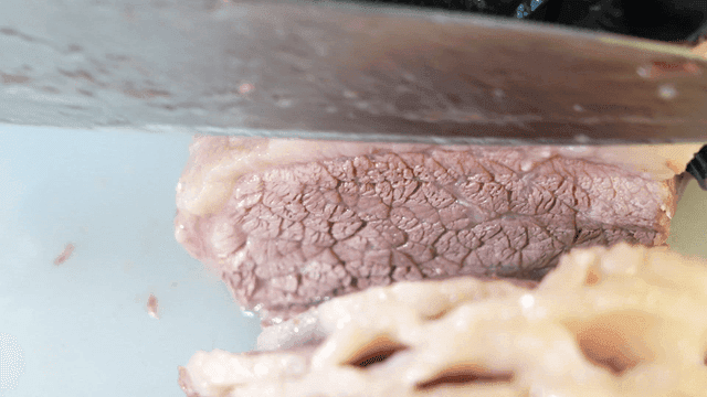Slicing tender boiled meat on a board